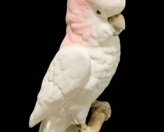 2300 - Royal Dux Bird Figurine 16" (Description): Royal Dux ceramic bird figurine depicting a  cockatoo perched on a branch with leaves atop  an oval base. Measures 16 inches tall.