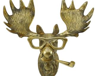 116 - Whimsical Moose Wall Mount w/ Glasses & Pipe (Description): Whimsical brass moose head wall decor  featuring a moose wearing eyeglasses and  smoking a pipe. The piece displays detailed  antlers with textured surfaces and a  charming, humorous design. Finished in an antique brass tone with darker accents  highlighting the sculptural details. Measures  15"x17"x9".