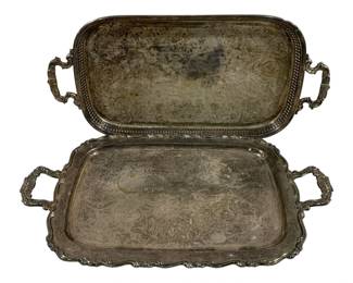 2021 - 2 Silver Plated Serving Platters (Description): Two silver plated serving platters with  ornate handles. Each platter features  decorative engraved designs on the surface.  Measures 20" x 13".