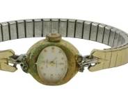 836 - 3 Vintage Ladies Watches w/ Leather Bands (Description): Collection of three vintage ladies watches.  The group includes two watches with dark  leather bands featuring round gold-tone  cases, one with a burgundy dial and Arabic  numerals, the other with a white dial. The third watch features a gold-tone expandable  bracelet band with decorative lugs and a  round white dial. All watches display classic  mid-century styling. Used as is electric/electronic/mechanical