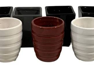 2345 - 9 Ceramic Vases 3.5" (Description): A collection of nine ceramic vases in  assorted colors and styles. The lot includes  black square vases, ribbed cylindrical vases  in white, brown, and black, as well as a  smooth purple vase. Each measures approximately 3.5 inches.