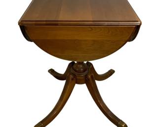 2008 - Duncan Phyfe Drop-side Table 27"x38"x38" (Description): A drop-side table featuring a classic  pedestal base with four splayed legs  terminating in brass capped feet. The table  measures 27 inches tall by 38 inches by 38  inches with the leaves extended.