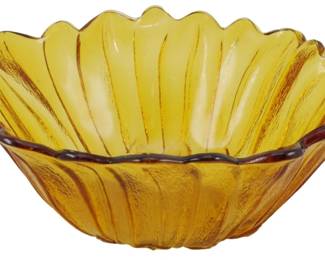 253 - Amber Poppy Glass Bowl 3"x7" (Description): Marigold carnival glass bowl featuring a  scalloped floral petal design with ribbed  sides radiating from the center. The  amber-gold iridescent glass displays  characteristic carnival glass coloring with deeper amber tones along the decoratively  scalloped rim. Measures 3 inches tall by 7  inches in diameter.