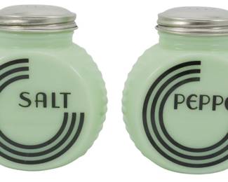 158 - Pair Jadeite Salt and Pepper Shakers 4.5" (Description): Jadeite glass salt and pepper shakers  featuring an Art Deco-inspired design with  bold black concentric circles and lettering  spelling out "Salt" and "Pepper" on each  respective shaker. The round, disc-shaped bodies have a scalloped edge detail and are  topped with metal lids. Each shaker measures  4.5 inches in height.