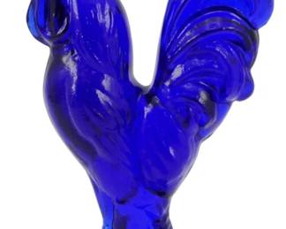 133 - Cobalt Glass Rooster Figure 4.5" (Description): Cobalt blue glass rooster figure standing on  a circular base. The piece features detailed  feather texturing throughout the body, tail,  and prominent comb. Measures 4.5 inches tall.