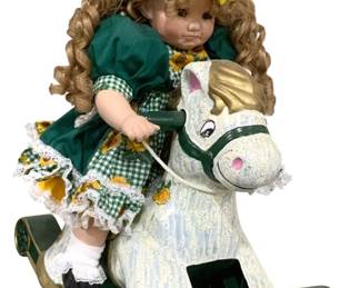 2445 - Porcelain Doll Riding Rocking Horse (Description): 21.5 x 17 - horse is plastic