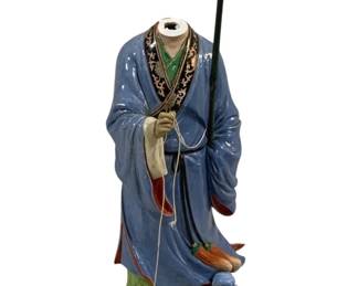 2112 - Oriental Figurine w/ Detached Head 16.5" (Description): Oriental ceramic figurine of a robed figure  holding a staff and string, with a detached  head. The figure wears a blue robe with green  pants and decorative trim. Measures 16.5  inches tall.