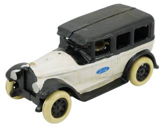 122 - Cast Iron Ford Car 3.5"x8"x3" (Description): Cast iron Ford car featuring a black and  white painted finish with cream-colored  tires. The model displays the classic Ford  oval logo on the side door and includes a  detailed driver figure. This decorative piece measures 3.5 inches high by 8 inches long by  3 inches wide.