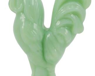 132 - Jadeite Glass Rooster Figure 4.5" (Description): Jadeite glass rooster figure in a soft,  opaque green color characteristic of classic  jadeite glassware. The rooster stands on a  rounded base with detailed feathering  throughout the body, wings, and tail. The figure features a prominent comb and wattle.  Measures 4.5 inches tall.