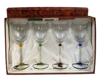 2066 - 4pc Set Fumo Wine Glasses in Box 8" (Description): A four-piece set of Funo wine glasses  presented in the original decorative box.  Each glass features a clear bowl with a  colored accent on the stem and base in  yellow, green, red, and blue. Each glass measures 8 inches tall.