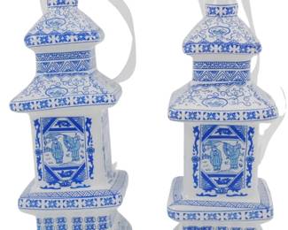 249 - Pr Blown Glass Chinoiserie Pagoda Ornaments (Description): Pair of Danny's Fine Porcelain Chinoiserie  pagoda ornaments featuring classic blue and  white decoration. Each ornament is styled as  a traditional tiered pagoda with hand-painted  scenic panels depicting figures in Asian dress, surrounded by intricate floral  scrollwork, geometric patterns, and lotus  motifs. The ornaments have silver-tone caps  with white ribbon hangers for display.  Measuring 5.5" tall.