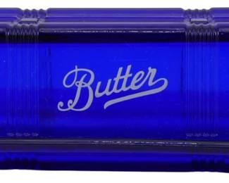 143 - Cobalt Glass Butter Dish 2.5"x6.5"x3" (Description): Cobalt blue glass butter dish featuring the  word "Butter" embossed in elegant script on  the lid. The covered dish has a classic  rectangular design with ribbed corner details  on the lid. Measures 2 1/2" x 6 1/2" x 3".