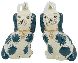 245 - Pr Blown Glass Staffordshire Dog Ornaments (Description): A pair of Danny's Fine Porcelain  Staffordshire dog ornaments. These charming  seated spaniels feature a classic blue and  white color scheme with gold-painted collars  and heart-shaped pendants. Each ornament has a gold cap with hanging loop at the top.  Measures 5 inches tall.