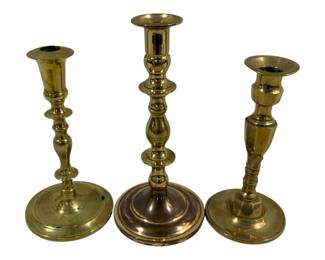 2344 - 3 Brass Candleholders 7.5"-9" (Description): A three-piece of brass candleholders in  varying heights and turned designs. Each  features a circular base with a classic  baluster-style stem. Heights range from 7.5  to 9 inches.