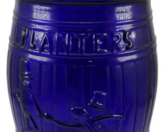 118 - Cobalt Glass Planters Jar w/ Lid 13"x8" (Description): Cobalt blue glass Planters peanut jar with  matching lid. The barrel-shaped jar features  the embossed "Planters" name and the iconic  Mr. Peanut character in relief on the front.  The lid is topped with a peanut-shaped finial. Measures 13 inches tally 8 inches in  diameter.