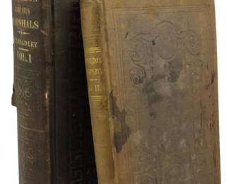 79 - 2 Single Volume of Sets 1800s Napoleon Books (Description): Two single volumes from 1800s Napoleon book  sets. The collection includes "Napoleon and  His Marshals" by J.T. Headley, Volume 1,  featuring an embossed dark cover with gilt  spine lettering. The second volume is "Napoleon Bonaparte," Volume II, with brown  embossed cover showing decorative scrollwork.  Both books display wear consistent with age,  including rubbing to the covers and spine.
