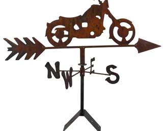 198 - Rustic Motorcycle Weathervane 26" (Description): Featuring a classic chopper-style silhouette  mounted on an arrow directional. The piece  includes a compass rose with N, W, E, and S  directional markers and sits atop a tripod  stand. The weathered patina finish gives it a vintage, rustic appearance. Measures 26  inches.