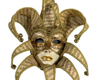 2048 - Mask Wall Art Made in Italy 16"x14" (Description): Decorative mask wall art made in Italy. This  ornate piece features a jester-style design  with elaborate gold trim and bells adorning  the extended points. The mask displays  intricate gold filigree work and music note patterned fabric. Measures 16 inches by 14  inches.