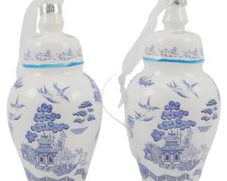 246 - Pair Blown Glass Chinoiserie Jar Ornaments (Description): A pair of Danny's Fine Porcelain Chinoiserie  jar ornaments in a classic blue and white  color scheme. These decorative ginger  jar-style ornaments feature traditional Blue  Willow-inspired designs depicting pagodas, birds in flight, and stylized trees. Each  ornament has a domed lid with a white ribbon  hanger attached at the finial, and a  turquoise accent band at the neck. Measures  5.5 inches.