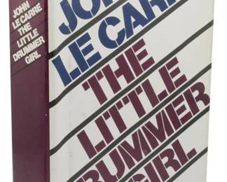 35 - 1983 1st Ed. The Little Drummer Girl w/ DJ (Description): First edition of The Little Drummer Girl by  John le Carré, published in 1983 by Knopf.  This hardcover copy retains its original dust  jacket featuring the distinctive typography  design with the title arranged diagonally in maroon lettering against a cream background.  The burgundy cloth binding is visible on the  spine. The dust jacket shows some light wear  to the edges consistent with age.