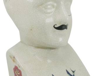 1023 - Ceramic Phrenology Head Figure 9.5" (Description): Ceramic phrenology head figure featuring a  decorative crackle glaze finish. The bust  displays a painted mustache, traditional  tattoo-style decorations including red roses  and blue swallows, and phrenology text markings across the head including "SeeNo  Evil." The piece measures 11 inches in  height.
