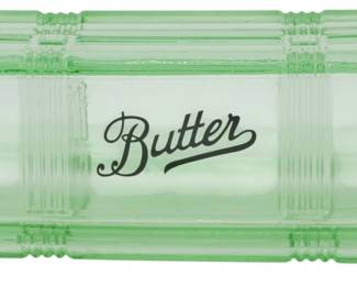 145 - Green Glass Butter Dish 2.5"x6.5"x3" (Description): Green glass butter dish featuring a  rectangular covered design with ribbed corner  details. The lid is embossed with the word  "Butter" in elegant script lettering.  Includes a matching base tray. Measures 2 1/2" x 6 1/x 3".