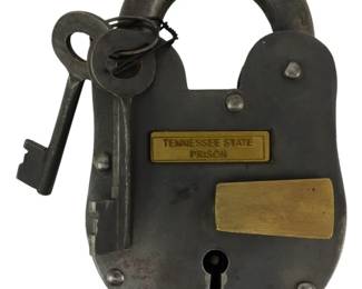 179 - Tennessee State Prison Lock w/ Keys 5" (Description): Tennessee State Prison lock with keys. This  heavy iron padlock features a distinctive  rounded body with brass plaques, including  one engraved "Tennessee State Prison." The  lock comes with two skeleton keys attached by a wire ring. Measures 5 inches.