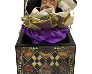 2086 - "Greensleeves" Musical Jack-in-the-Box (Description): A "Greensleeves" musical jack-in-the-box  featuring a jester figure. The decorative box  is adorned with a checkered diamond pattern  and floral rose motifs. Measures 6.5" x 6" x  6". Used as is electric/electronic/mechanical  item. No guarantee all components, untested.