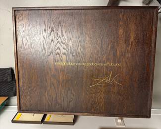 Wooden presentation box for "Imaginations and Objects of the Future." The complete portfolio, comprising 11 intaglios and lithographs printed in colors, six with collage, and including Dalinean Prophecy; 1975, each signed in pencil and inscribed 'LVI/LXXV', the prints on Japon, the cover sheets on wove, with title and justification pages and introductory text in English by the artist and publisher.