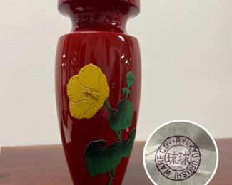 A charming Ryukyu Urushi ware red lacquered wooden vase, 8 inches tall, with a striking raised yellow hibiscus flower design on the side. The vase has a metal insert to hold water for flowers.