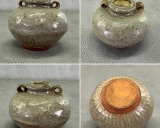 A celadon-glazed jarlet, Thailand 14th-16th century; compressed round body with short neck with two hollow handles, raised lotus petal motif around the bottom. Size: 3-1/4"W x 2-1/8"H.