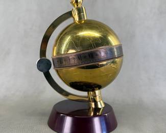 A vintage limited edition Charles Frodsham brass globe desk clock, with engraved world map and a unique silvered time-indicator shaped like a fish tail, edition number 0310/5000 engraved on the central winding plate; this clock does run. Created exclusively for The Heritage Collection, comes with the original certificate of authenticity, and letter with globe clock care recommendations from Charles Frodsham & Co Ltd.