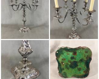 An exquisite antique silver plated five-light candelabra featuring four gracefully extending S-scroll arms adorned with applied stipple and chased leaf motifs, culminating in foliate repoussé drip pans and baluster-shaped candle cups with matching foliate-chased bobeches. The central candle cup crowns the highly ornamented standard. The five-light section is removable so that the baluster form base, richly embellished with foliate scrollwork, can be used as a single candlestick! Maker's mark to the underside of the five-light section, where it fits into the base. 18-1/2"Wx 19"H.