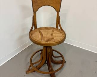 One of a pair of antique circa 1920 bentwood and rattan swivel drafting or telephone operator stools w/adjustable wooden and metal base