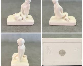 Rare antique Rookwood Pottery Art Deco-style ceramic figurine (model number 2868) designed by artist Louise Abel for Rookwood Pottery, featuring a nude female figure with a bob haircut, seated on a rectangular base. The object is finished in a creamy white, high-gloss glaze. The underside of the base features impressed manufacturer’s marks, including the Rookwood sunburst logo and the shape number 2868. Additional marks include a molded stylized triangle or ‘A’ symbol, and Roman numerals date stamp for 1932.