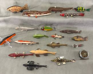 A collection of antique hand-carved wooden fishing decoys, many with metal fins and tails and original paint.