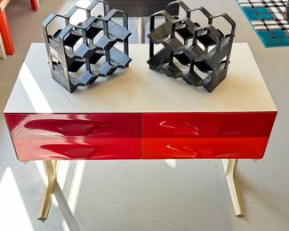 A circa 1968 Raymond Loewy DF2000 chest of 4 drawers in gleaming shades of red, by famed 20th Century industrial designer Raymond Loewy for Doubinsky Freres. Loewy's Compagnie de L’Esthetique Industrielle (CEI) in Paris created the design of the DF 2000 modern furniture line, then manufactured by Doubinsky Frères and sold in the United States beginning in 1968. These iconic pieces were only manufactured until the early 1970s. Shown with two vintage MCM 1960's OrnaPress modular 6 bottle wine racks.