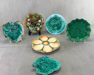 An assortment of vintage and antique majolica ware platters and dishes