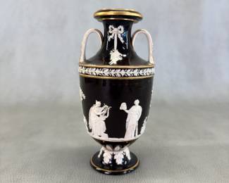 Antique 1850's Wedgwood black dip jasper ware double handled urn shaped vase, 7-1/2"H, with applied classical figures in white relief depicting the muses of comedy/drama, music, poetry; covered overall in a shiny clear glaze and with applied gilding. Wedgwood stamp to the base along with group of 4 "mustache" marks, and hand-incised numerals 350. See example in of this vase in the Nelson Provincial Museum, Australia.