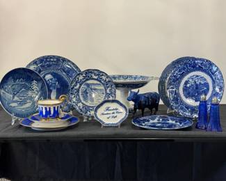 A Bing & Grondahl 1964 Christmas plate, a vintage blue and white transferware collector plate featuring a central depiction of Niagara Falls, a Westland Giftware Jazzy Cow figurine, a pair of cobalt blue depression glass “Mayfair” pattern salt and pepper shakers, 4.25” tall