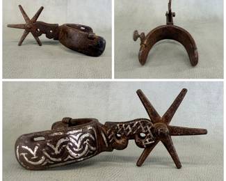 Antique Mexican Charro iron spur featuring hand-forged details, ornate silver inlay patterns on the heel band and figure-eight shank, and a large multi-point rowel