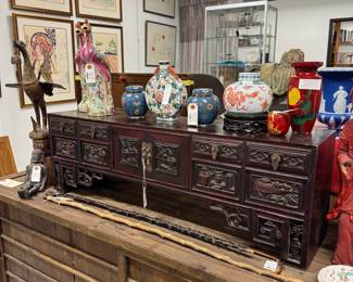 A wonderful selection of Asian art including Japanese Ryukyu Urushi ware and Amita damascene ware, Chinese export porcelain and cloisonné, Thai temple statues, Japanese tea room cabinets, antique Chinese silk kesi dragon robe, and an antique hardwood Chinese lady's chest or scholar’s cabinet (a low kang cabinet) with six small drawers and central cupboard; with relief carvings of flowers and peaches. Lots to see at this sale!