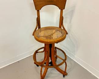 Second of the pair of antique circa 1920 bentwood and rattan swivel drafting or telephone operator stools w/adjustable wooden and metal base