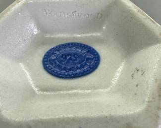 Closeup of base of rare antique c. 1820 Wedgwood white jasper two-handled vase with waxen sheen finish and applied blue sprig classical Greek figures and both arts and military symbols decoration. Stamped Wedgwood to the base – each letter individually stamped in —and a blue sprig oval embossed "pad mark" showing the numerals 979 for the shape number. 8"H x 3"W.