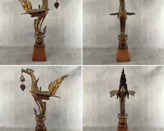 More views of the Thai gilt temple bird sculpture, known as a Hong or Hamsa (a sacred swan or mythical goose in Thai-Buddhist mythology), holding a small wind bell in its mouth, and mounted on a wooden base. Gilded metal, 25-1/4 inches tall including the base.