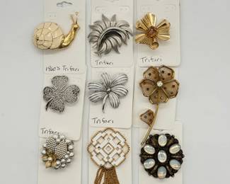 Fun vintage Trifari brooches including enameled and gold-tone snail, brushed silver tone flower blossom, feathers; a four-leaf clover brooch in openwork silver-tone finish, and more