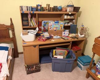 Desk showing games, office supplies, craft supplies, HP printer with ink