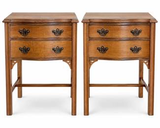 Pair of matching vintage wooden nightstands or bedside tables featuring elegant serpentine-front construction, two spacious drawers, molded tops, slender fluted-style legs, decorative pierced corner details and lower stretchers. Each drawer is fitted with ornate dark metal Chippendale-style bail pulls that complement the traditional design. Warm medium-brown finish displays attractive wood grain throughout. Each nightstand measures approximately 19 inches wide x 14 inches deep x 27 inches high. Drawers provide useful bedside storage while the tall, narrow proportions make the pair well suited for use as nightstands, end tables or accent tables. Vintage pre-owned condition with expected signs of age and use including scratches, scuffs, finish wear, small marks and edge wear; please review all photographs carefully for condition and construction details. Offered together as a matching pair.