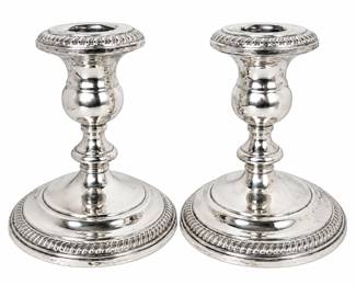 Elegant pair of weighted sterling silver candlesticks featuring a classic baluster form with broad circular bases, turned stems, and decorative ribbed detailing around the bases and candle cups. The polished sterling surfaces retain visible patina and signs of previous use, giving the pair an attractive traditional character. Weighted construction provides stability for tabletop, mantel, dining, or formal display. Marked sterling; weighted construction. Vintage condition with surface scratches, tarnish, oxidation, and age-related wear as shown. Please review photographs for condition and details.