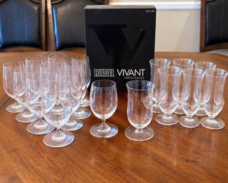 Large collection of Riedel Vivant clear crystal barware featuring an assortment of beer and beverage glasses in multiple shapes and sizes. Collection includes tall pilsner-style glasses, stemmed beer glasses and additional coordinating drinking glasses, along with an original Riedel Vivant four-glass box. The simple, elegant profiles showcase Riedel’s classic European glassware styling and make this a versatile collection for serving pilsners, lagers, ales and other beverages. Pre-owned condition with light wear consistent with use and storage. Original box shows storage wear. Collection is offered together as shown; please review photographs for exact quantities, styles and condition.
